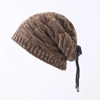 Brown knitted beanie with a drawstring on a light gray background