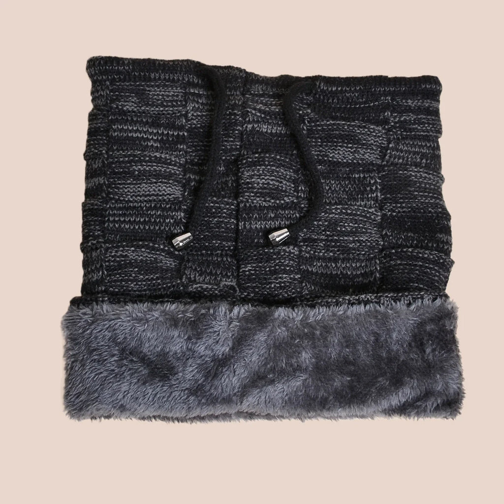 Folded black knit beanie scarf with fur trim on a beige background
