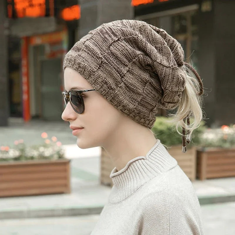 Woman wearing a knitted beanie and sunglasses in an urban setting