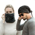 Two people wearing black knit face masks and hats on a white background