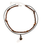 Necklace with brown beaded chain and pendant on a white background