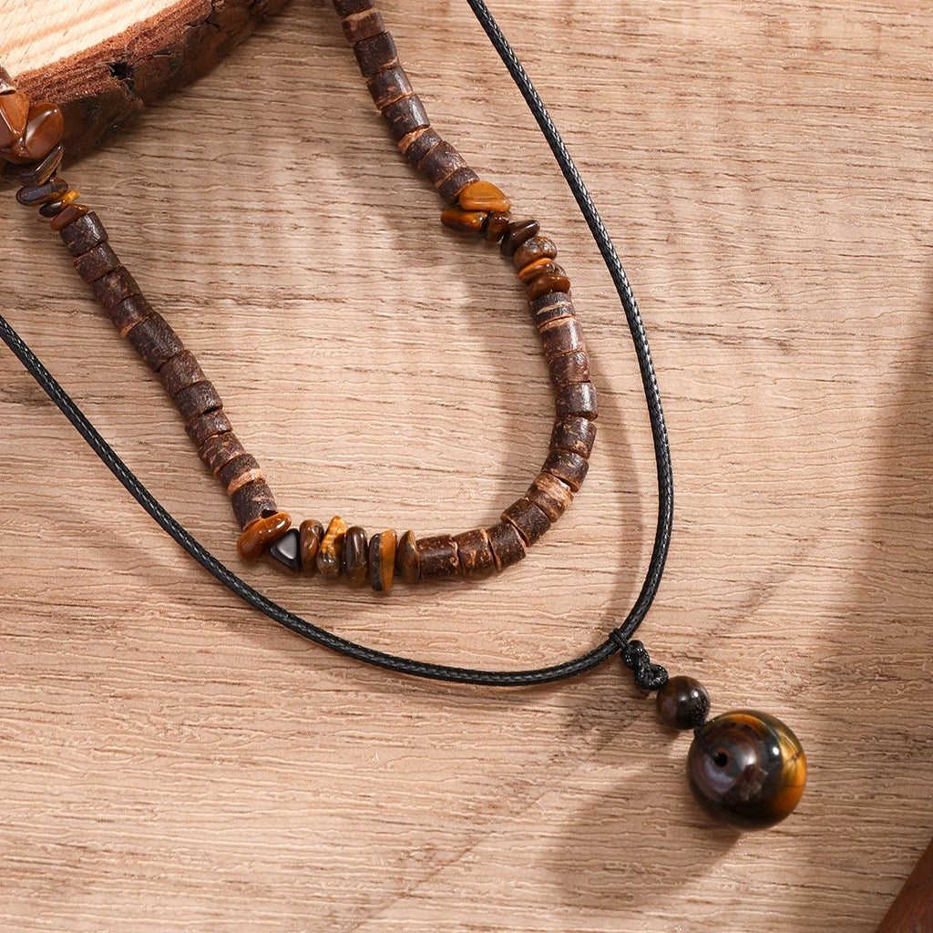 Beaded necklace with brown and black beads on a wooden surface