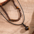 Beaded necklace with brown and black beads on a wooden surface
