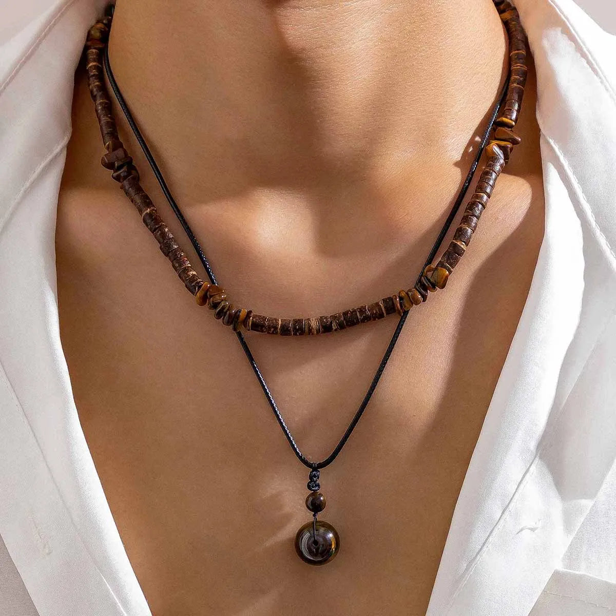Necklace with brown beads and a pendant on a mannequin with a white background