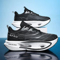 A pair of black and white athletic sneakers with a textured mesh upper and thick cushioned soles, displayed on a reflective surface against a light blue background.