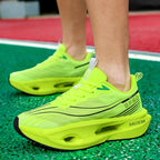 Neon green running shoes on a green sports field