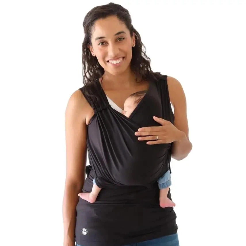 Woman holding a baby in a black wrap against a white background