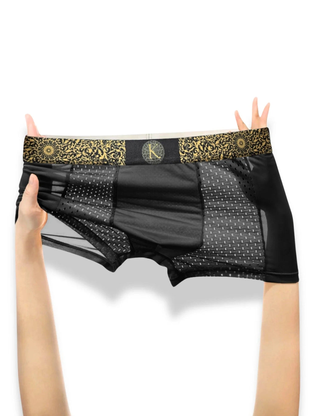 Black underwear with gold lace trim held by hands on a white background