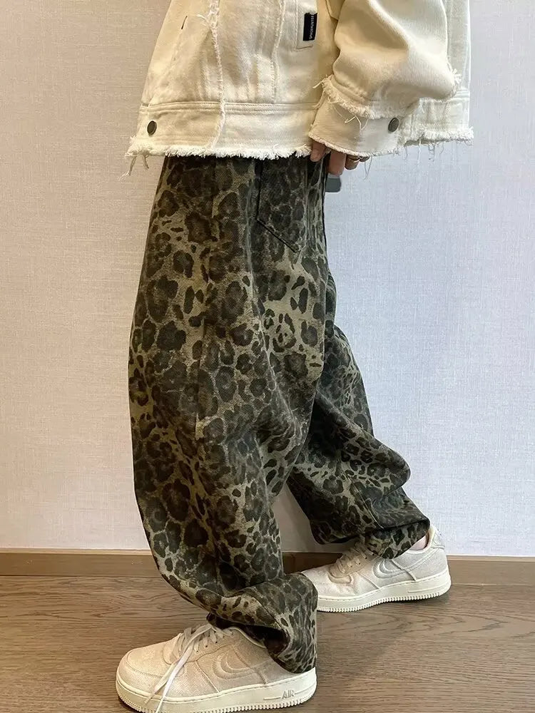 Person wearing leopard print pants and a light-colored jacket indoors.