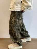 Person wearing leopard print pants and a light-colored jacket indoors.
