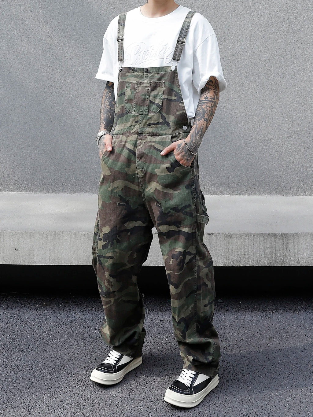 Person wearing camouflage overalls with a plain background