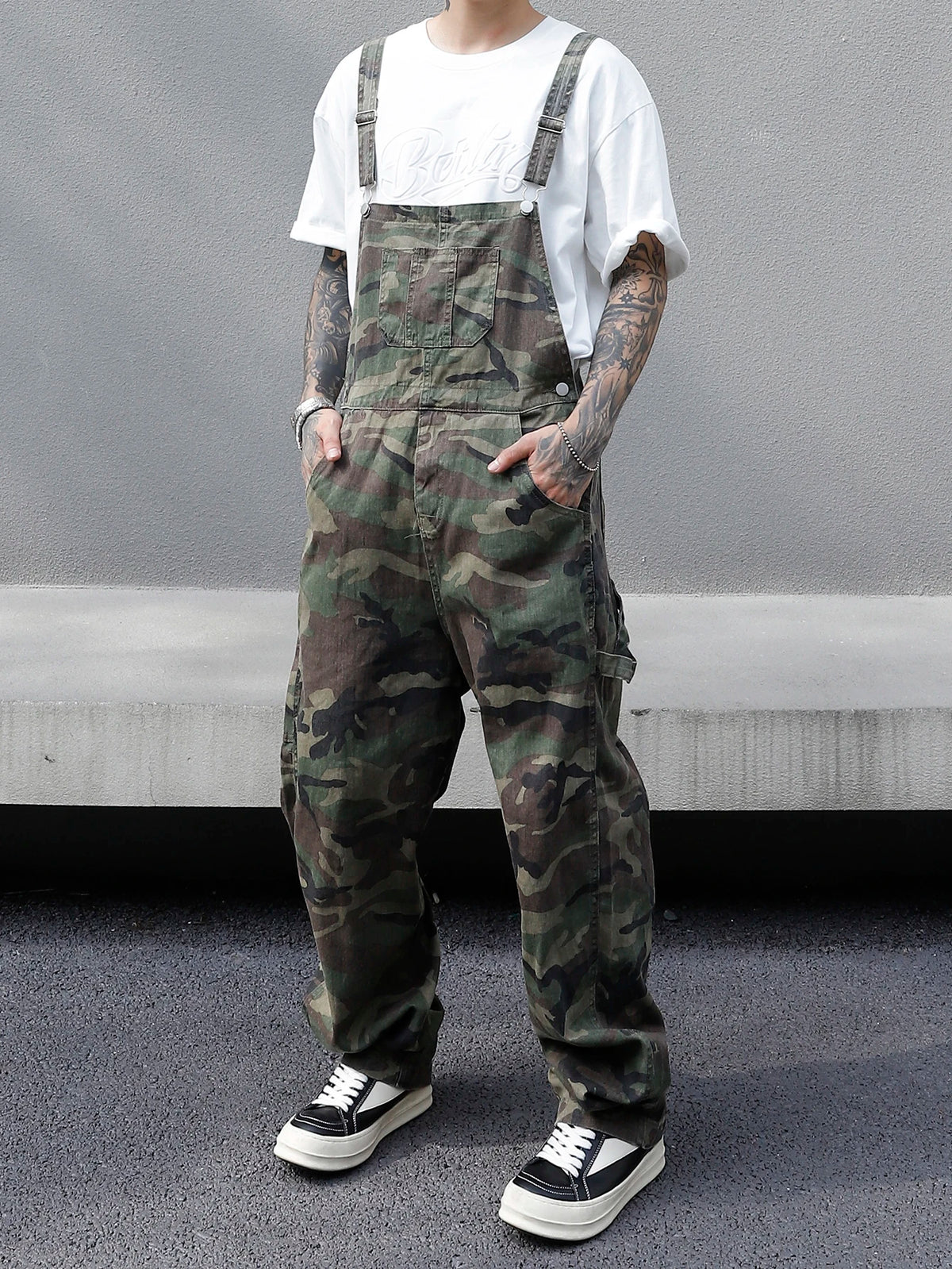 Person wearing camouflage overalls with a plain background