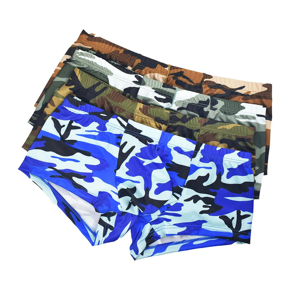 A stack of five pairs of men's boxer briefs with camouflage patterns in various colors, including blue, brown, green, black, and white, shown on a plain white background.
