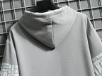 Gray hoodie with text on sleeves against a grid background
