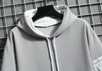Gray hoodie on a hanger against a grid background