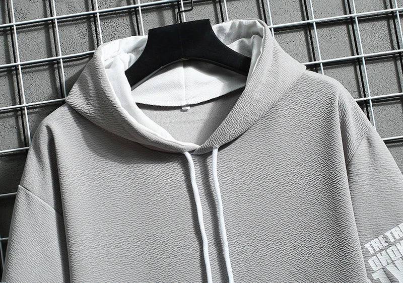 Gray hoodie on a hanger against a grid background