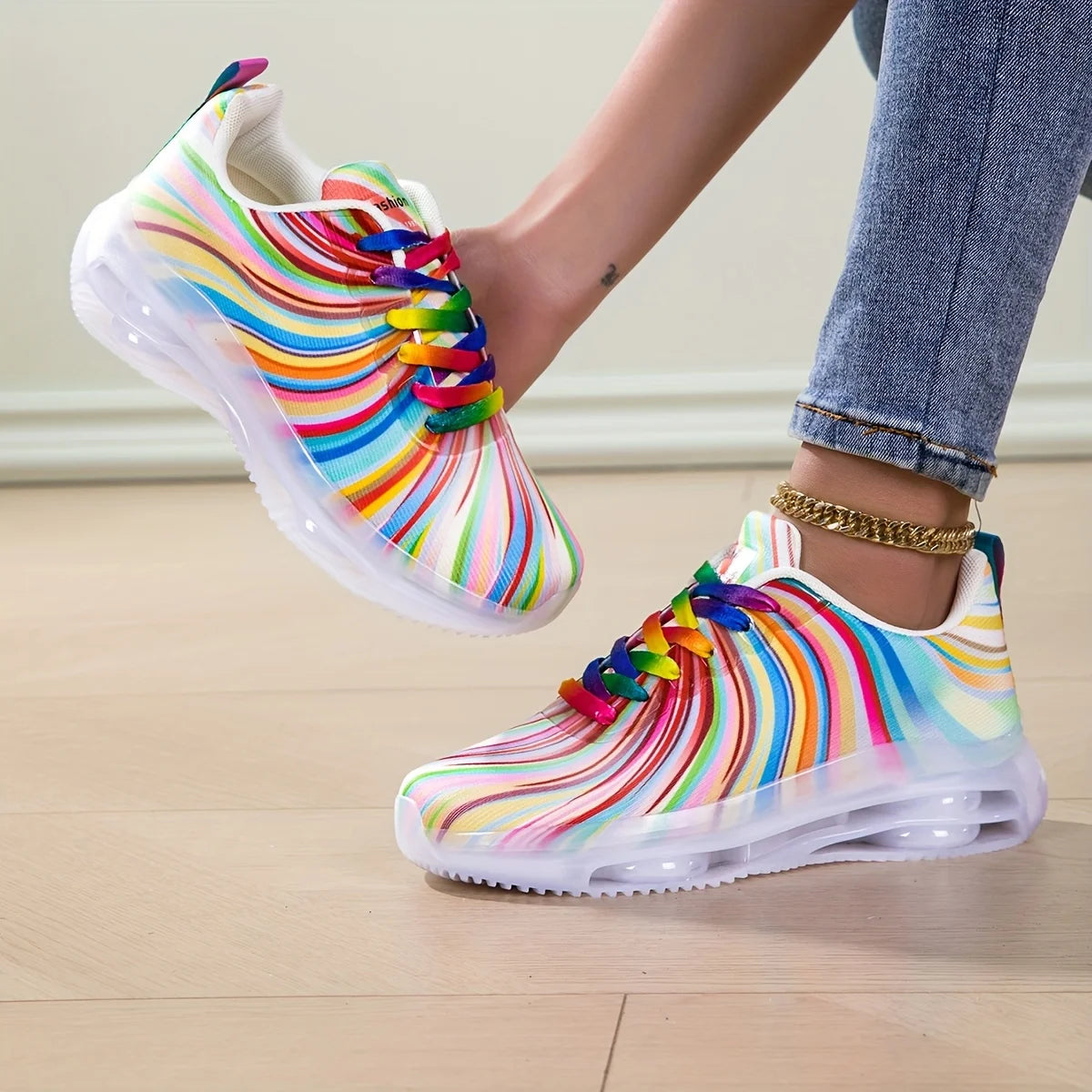 Colorful striped shoes worn with jeans on a light wooden floor.