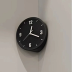 A minimalist black round wall clock with white numerals and hands, mounted on a light gray corner wall.