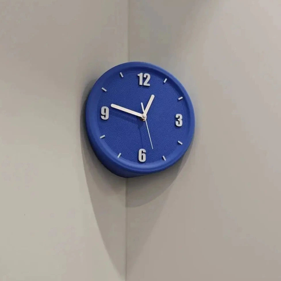 A round blue wall clock with white numerals and hands, mounted on a light gray corner wall.