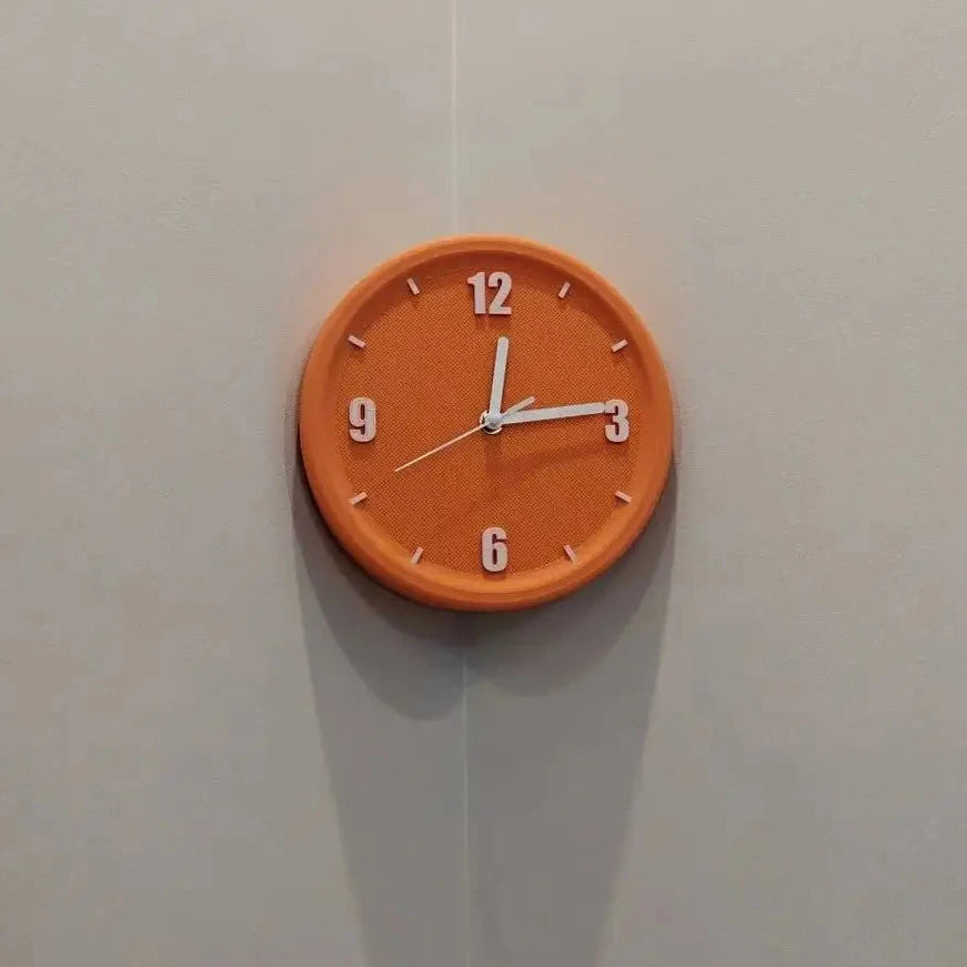 An orange round wall clock with white hands and white numerals, mounted on a light gray wall.