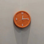 An orange round wall clock with white hands and white numerals, mounted on a light gray wall.
