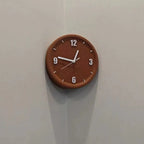 A round wall clock with a warm brown wood-grain finish and white hands, mounted on a light gray corner wall.