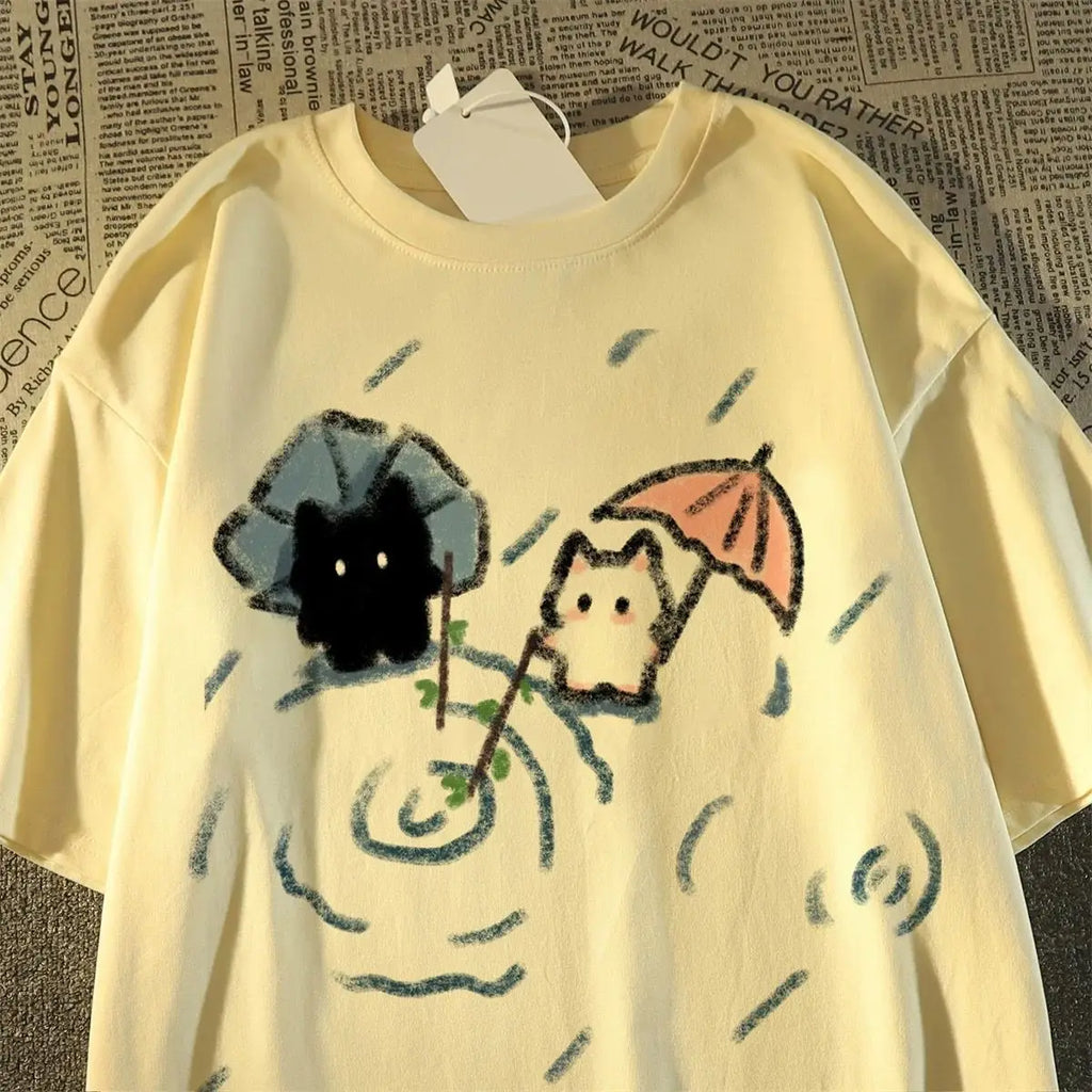 Yellow t-shirt with cat cartoon characters holding umbrellas on a textured background