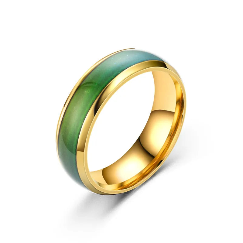 Gold ring with green inlay on a white background