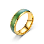 Gold ring with green inlay on a white background