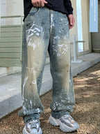 Person wearing light blue jeans with white paint splashes outdoors.