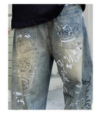 Gray jeans with white and black graffiti-style writing on a plain background