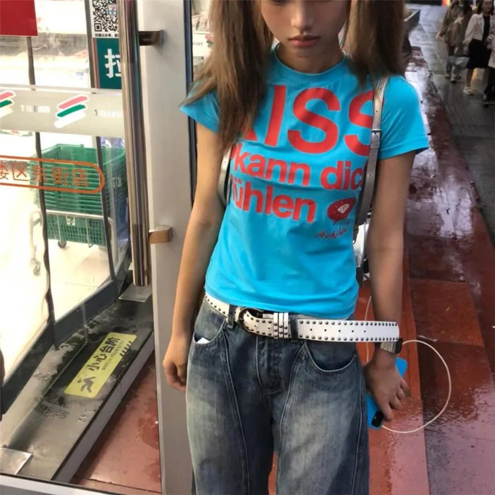 Person wearing a blue Kiss T-shirt Fashion Vintage Harajuku Streetwear  with red text in an indoor setting.