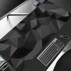 Desk setup with geometric-patterned desk pad, keyboard, mouse, and monitor.