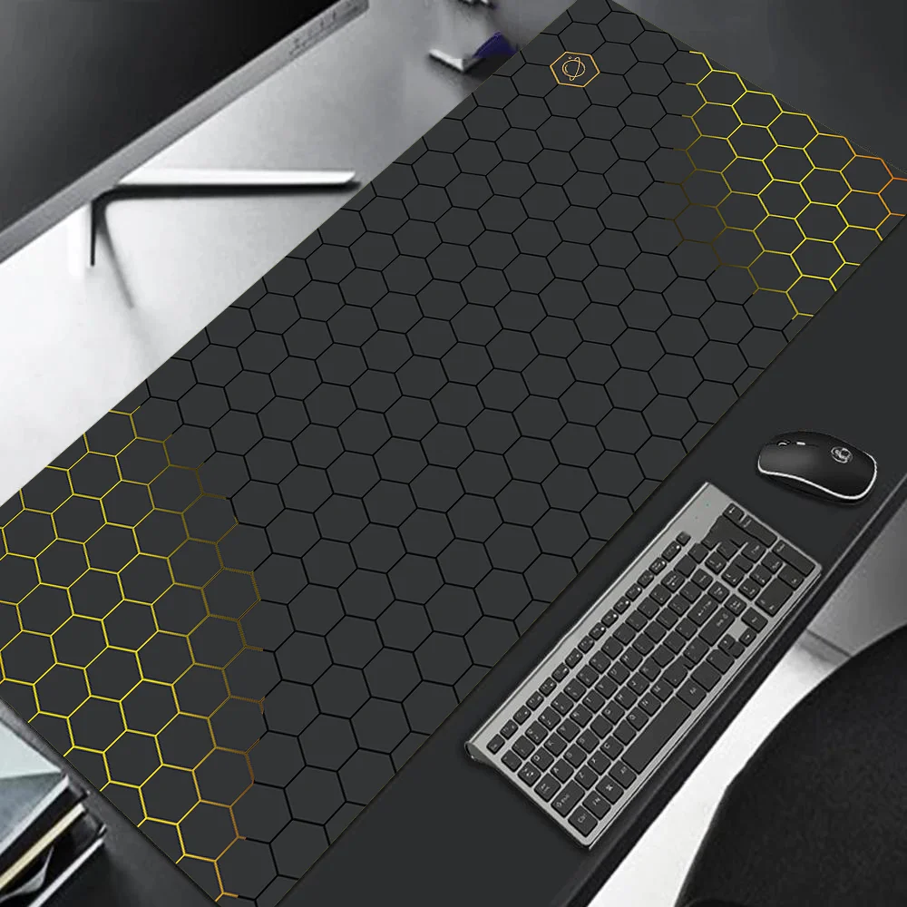 Large black desk mat with hexagonal pattern on a desk with keyboard and mouse.