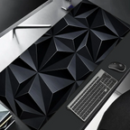 Geometric black desk mat on a desk with a keyboard and mouse.