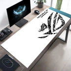 A large white desk mat with a black ASUS ROG 'Republic of Games' logo and text, laid out on a wooden desk in a modern home office setup.