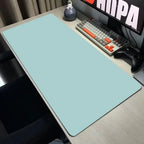 Desk setup with a large light blue mouse pad, keyboard, and monitor.
