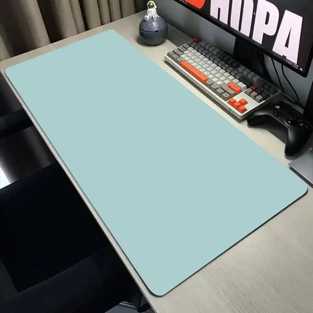 Desk setup with a large light blue mouse pad, keyboard, and monitor.