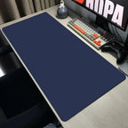 Blue mouse pad on a desk with a keyboard and monitor in the background