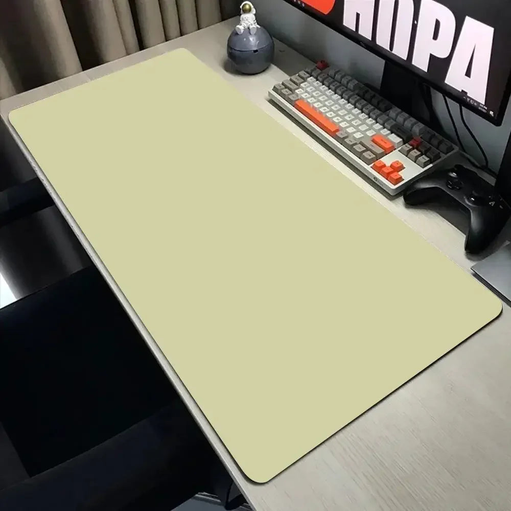 Desk setup with a large mouse pad, keyboard, and monitor on a desk.