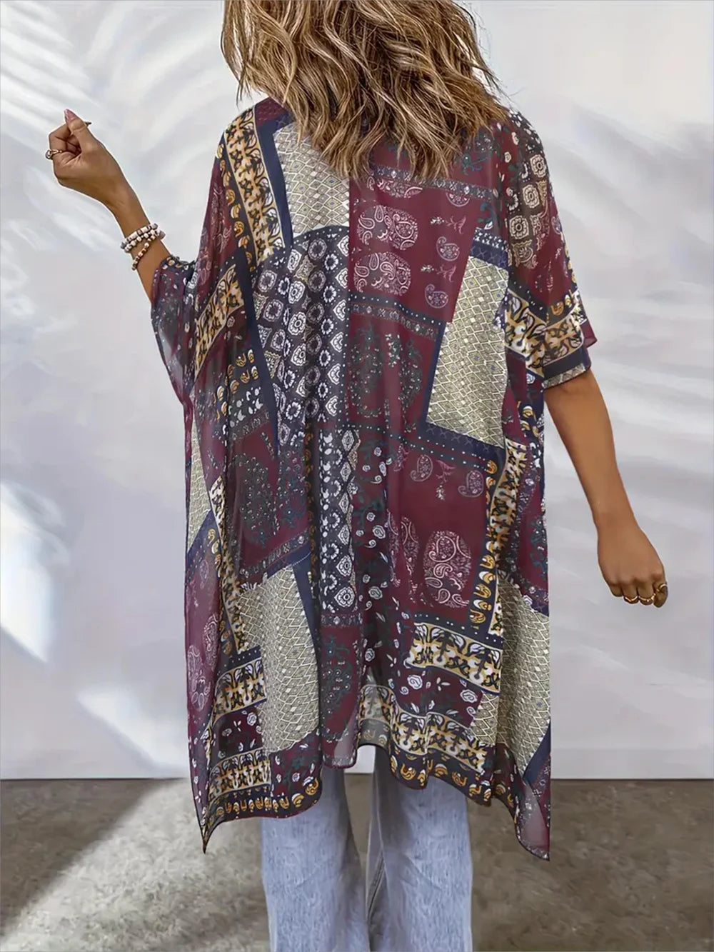 Person wearing a patterned kimono-style garment against a plain background