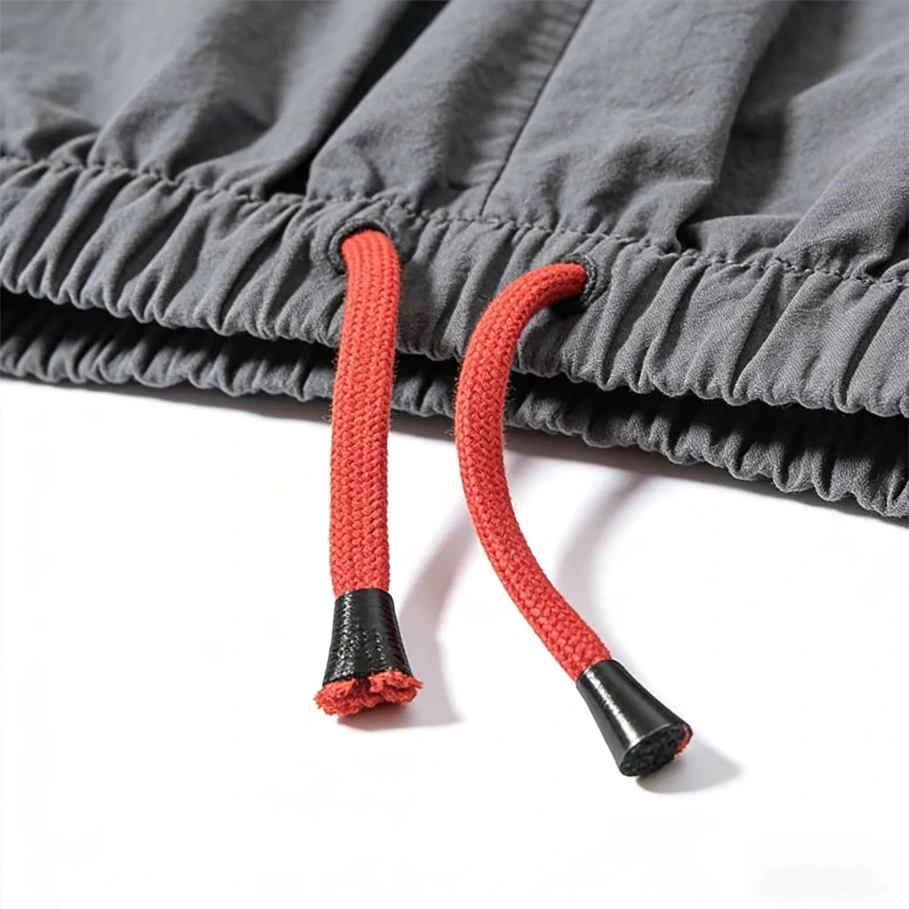 Close-up of gray pants with red drawstrings on a white background