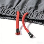 Close-up of gray pants with red drawstrings on a white background