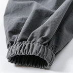 Close-up of gray pants with an elastic waistband on a white background