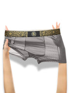 Gray underwear with decorative waistband held by hands on a white background