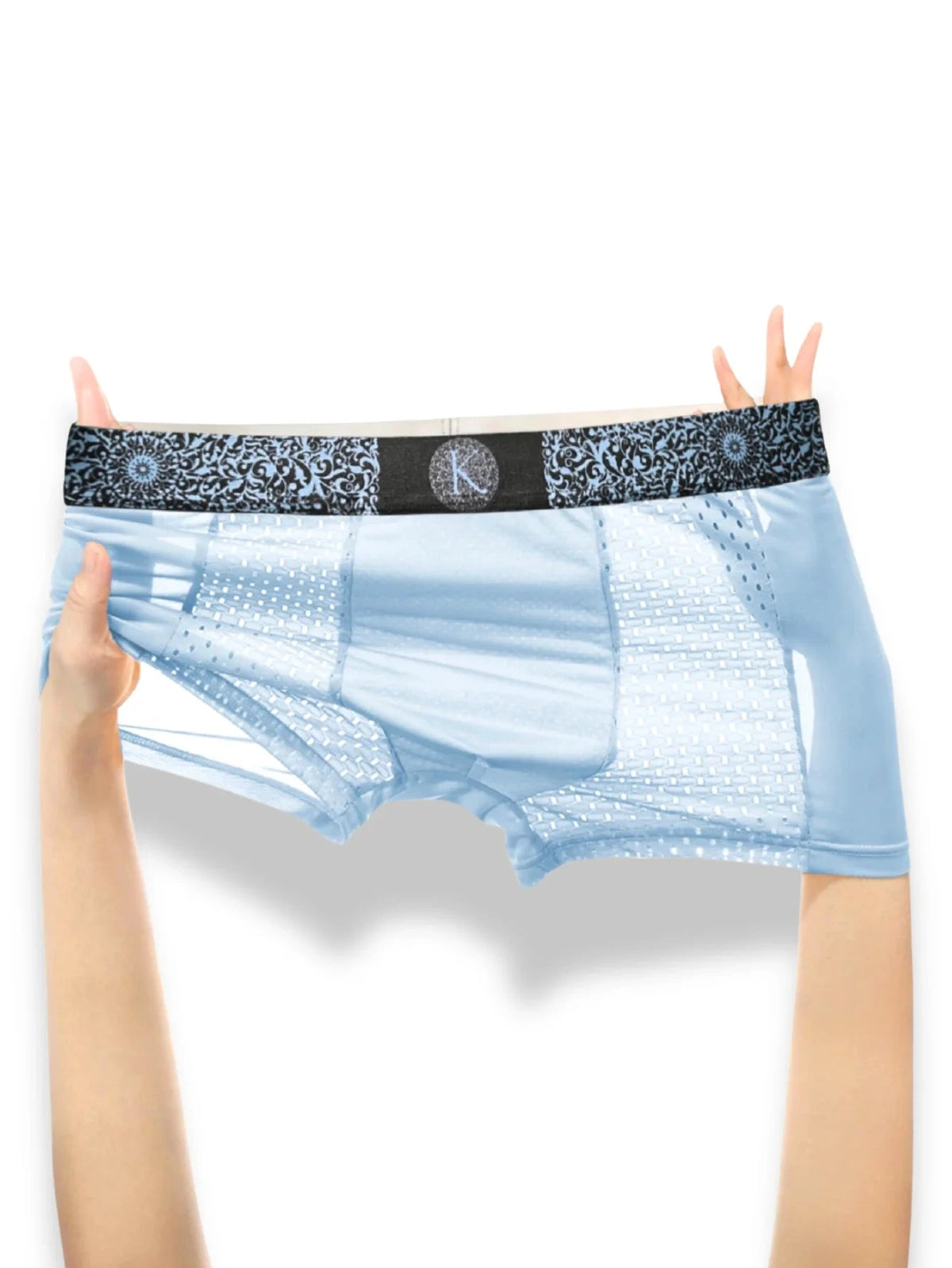 Light blue men's briefs with a black patterned waistband and a central monogram logo, held up by a person's hands against a white background.