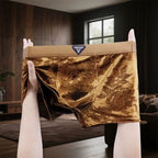 A pair of men's briefs with a luxurious gold brocade floral pattern and a beige waistband.