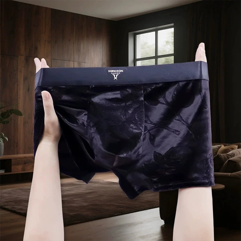 A pair of men's boxer briefs in dark navy blue satin with a subtle floral jacquard pattern.