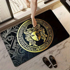 Decorative doormat with gold Medusa design on a marble floor.
