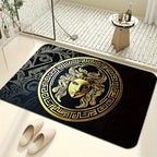 A bath mat with a large gold Medusa head emblem and Greek key border on a bathroom floor.